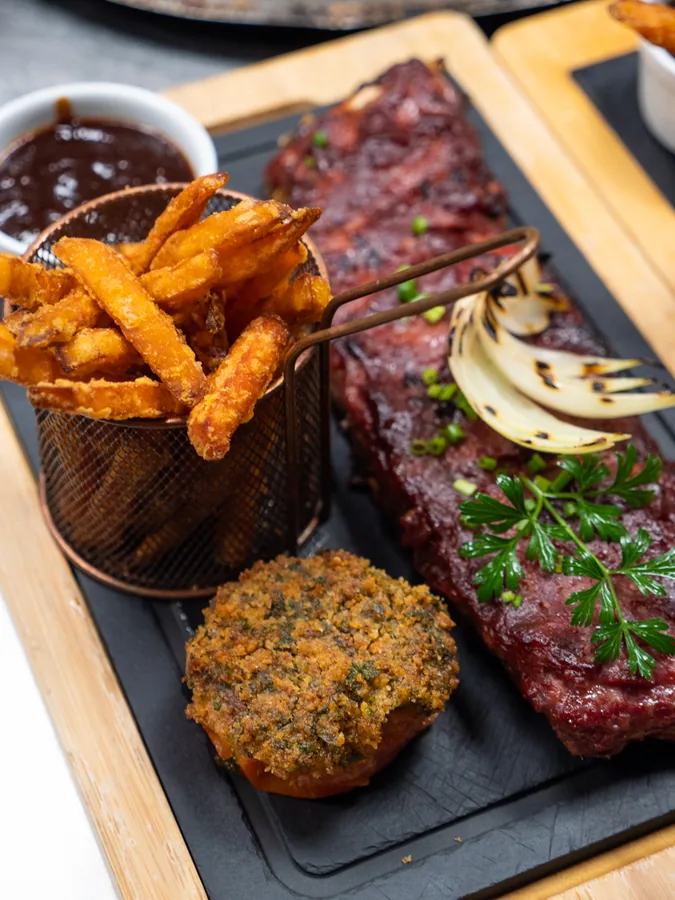 Travers de porc BBQ glacés, frites de patate douce, oignons grillés